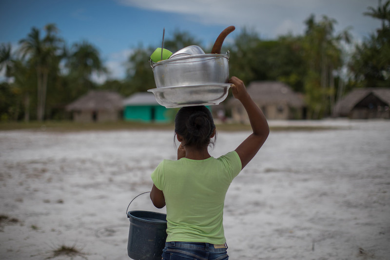 A Baniwa girl carries dishes in the Canadá community, near the Ayari River, in the Alto Rio Negro Indigenous Land (AM) @Carol Quintanilha / ISA