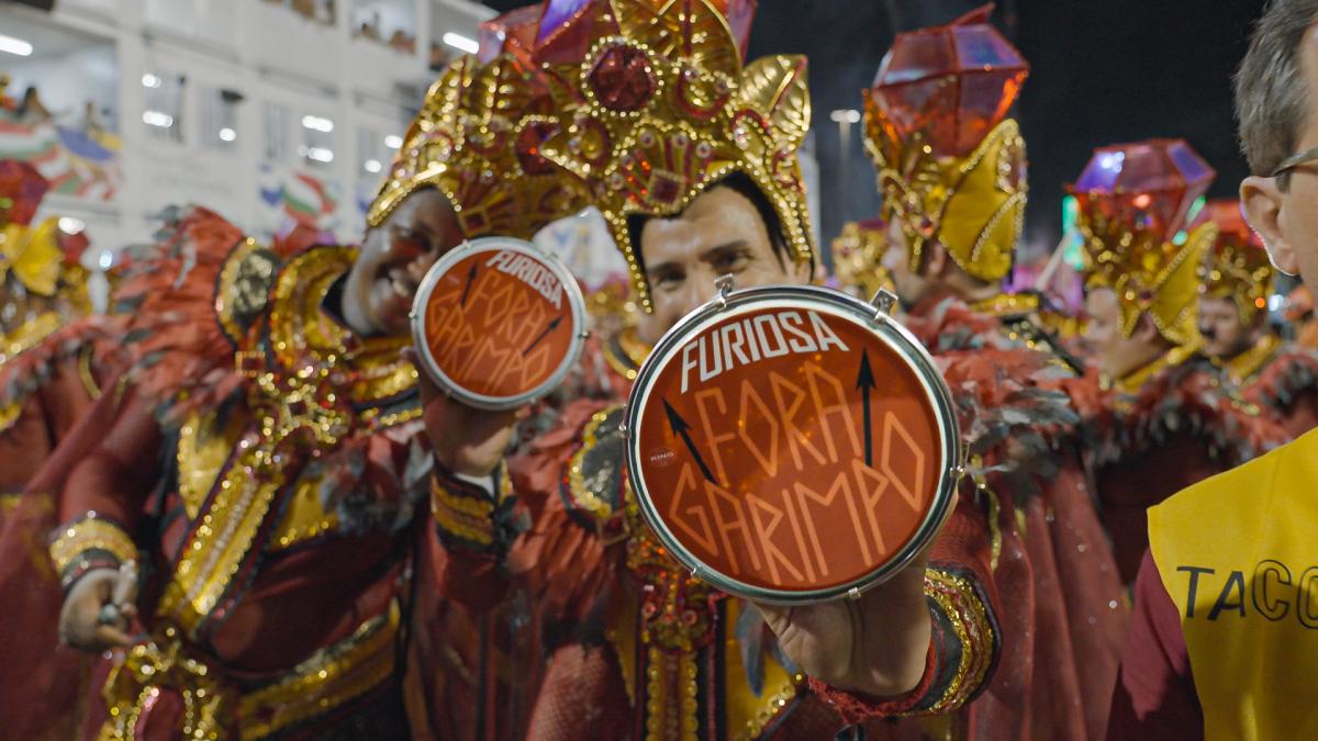 Ritmista do Acadêmicos do Salgueiro segura tamborim com o escrito “Fora Garimpo”