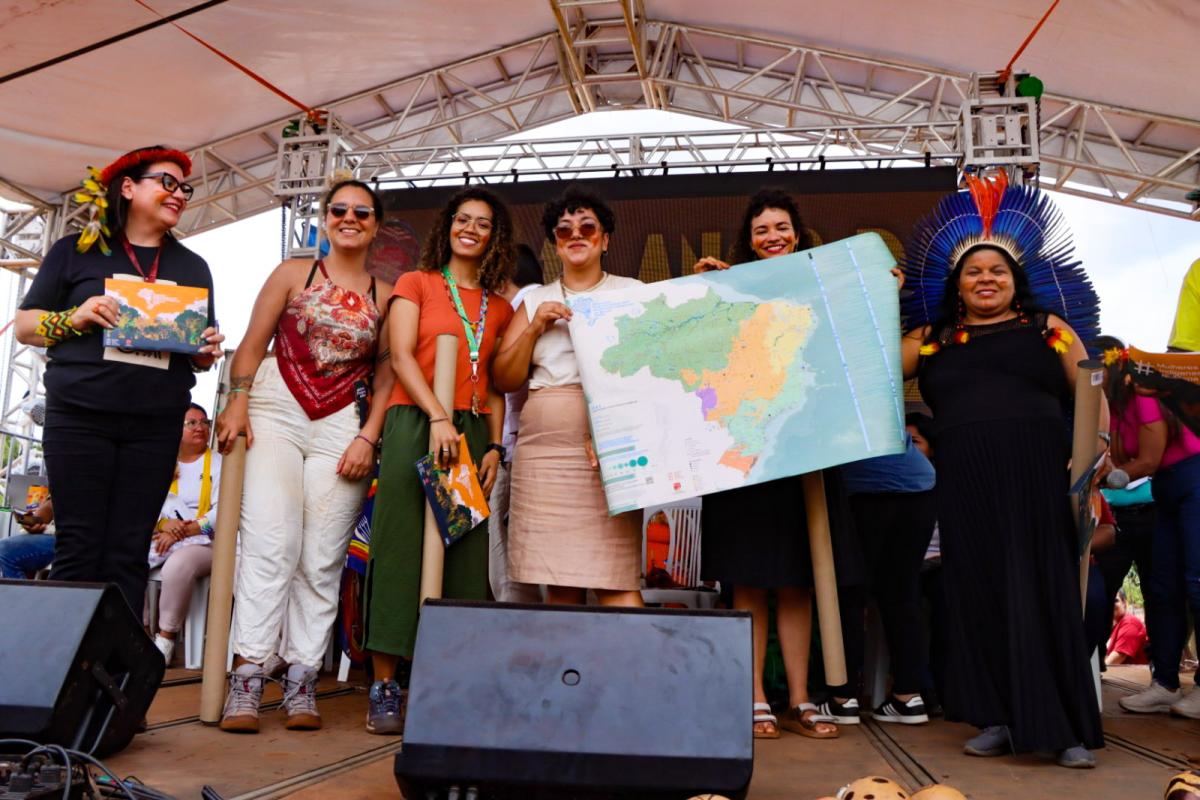 Na foto, da esquerda para a direita: Jozileia Kaingang, diretora-executiva da Anmiga; Mariana Soares, jornalista no ISA; Michelle Lira, assistente em geoprocessamento no ISA; Tatiane Klein, pesquisadora no ISA; Luma Prado, pesquisadora no ISA; e Sonia Guajajara, ministra dos Povos Indígenas, seguram o Mapa das Organizações das Mulheres Indígenas no Brasil em 2024, na abertura da Conferência das Mulheres Indígenas 2024/2025