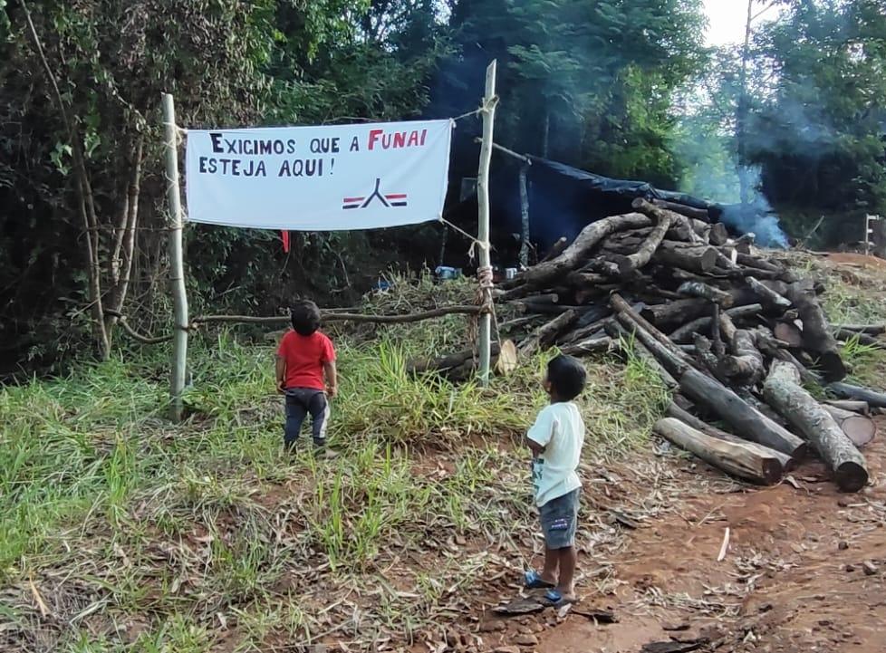 Crianças olham a faixa escrita "Exigimos que a Funai esteja aqui"