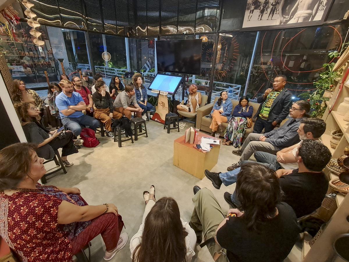 Karin Juruna, falando ao microfone no lançamento do livro Florescendo nas brechas: territórios tradicionais e economias da sociobiodiversidade