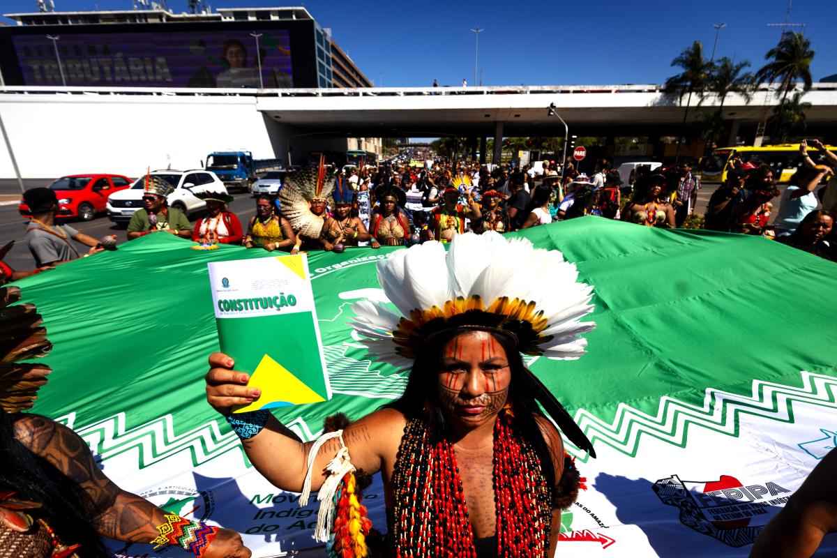 Indígena segura a Constituição na 3ª Marcha das Mulheres Indígenas, em 2023, em Brasília | Webert da Cruz Elias / ISA