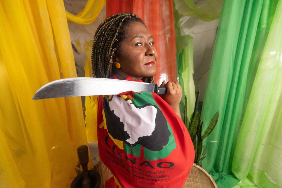  Vercilene Francisco Dias, Advogada do Quilombo Kalunga,.de Cavalcante-GO, posa para foto segurando bandeira da CONAQ e um facão