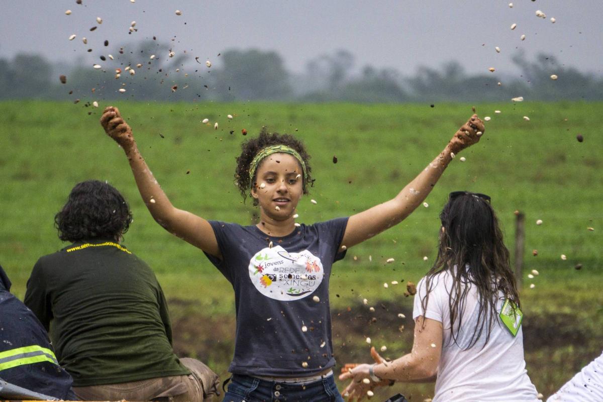 Milene Alves, quando jovem coletora da Rede de Sementes, auxilia no plantio de uma Muvuca de Sementes no Mato Grosso