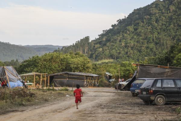 Criança correndo em assentamento construído às margens da barragem norte na Terra Indígena Laklãnõ